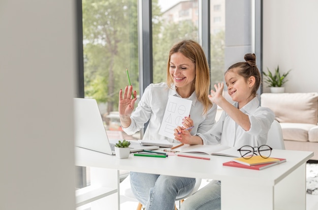 Kleines Mädchen, das mit ihrem Lehrer drinnen studiert