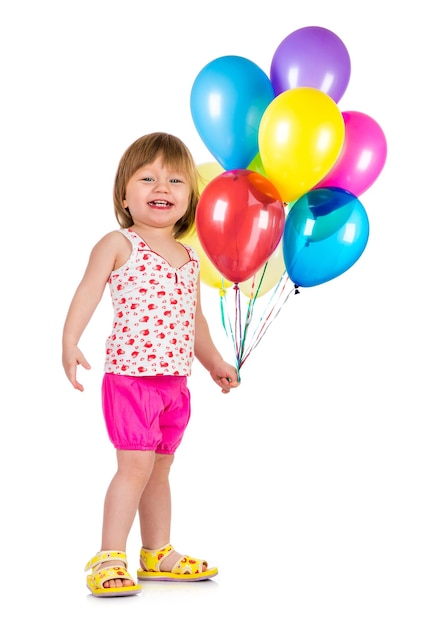 Kleines Mädchen, das mit Luftballons auf weißem Hintergrund lächelt