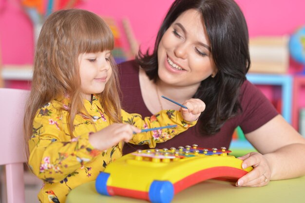 Kleines Mädchen, das mit Mutter spielt