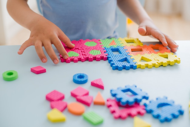 Kleines Mädchen, das mit Puzzlespiel, Früherziehung spielt