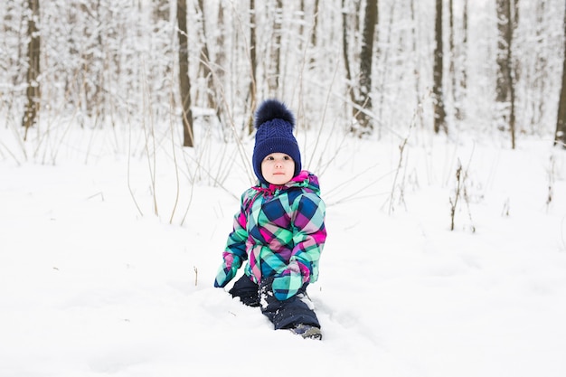 Kleines Mädchen, das mit Schnee spielt