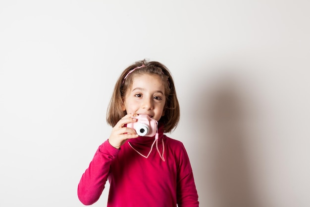 Kleines Mädchen, das mit Spielzeug-Fotokamera fotografiert