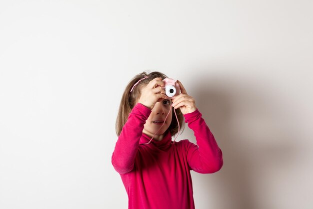 Kleines Mädchen, das mit Spielzeug-Fotokamera fotografiert