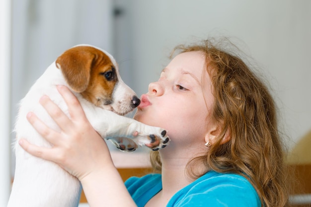 Kleines Mädchen, das mit Welpenjack Russell spielt