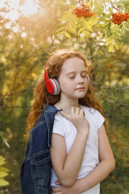 Kleines Mädchen, das Musik auf Kopfhörern hört.