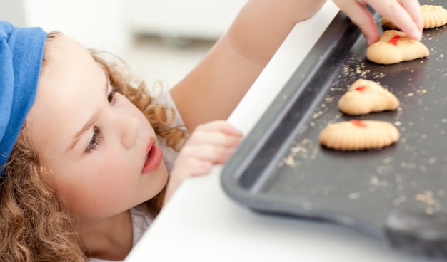 Kleines Mädchen, das Plätzchen stiehlt