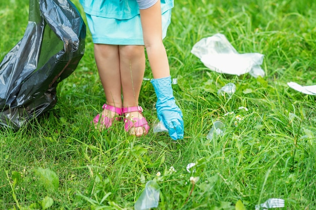 Kleines Mädchen, das Plastikmüll sammelt