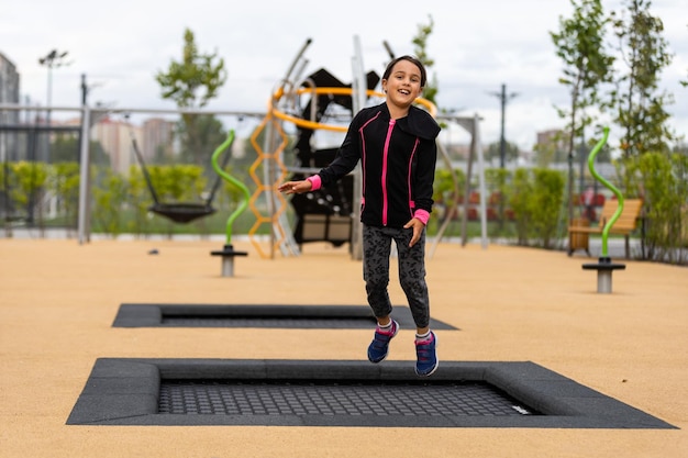 Kleines Mädchen, das Spaß beim Spielen auf dem Sportplatz hat