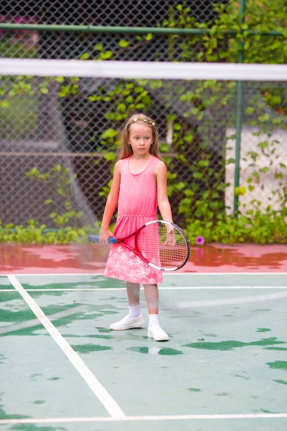 Kleines Mädchen, das Tennis auf dem Gericht spielt