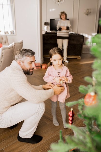 Kleines Mädchen, das Weihnachtsbaum verziert