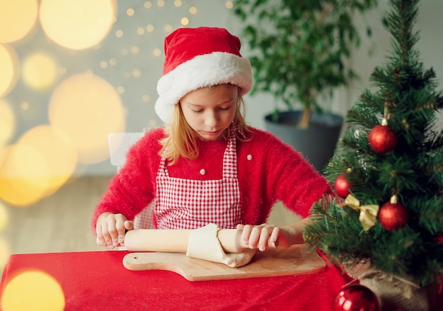 kleines Mädchen, das Weihnachtsplätzchen macht