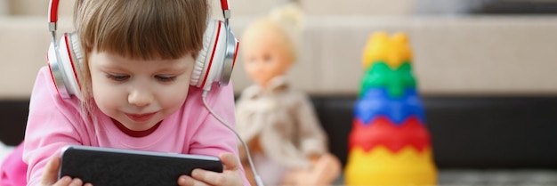 Kleines Mädchen, das Zeichentrickfilme auf dem Smartphone anschaut, digitale Unterhaltung für Kinder