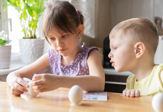 Kleines Mädchen dekorieren Ostereier zu Hause Vorbereitung für Ostern Konzept selektiver Fokus