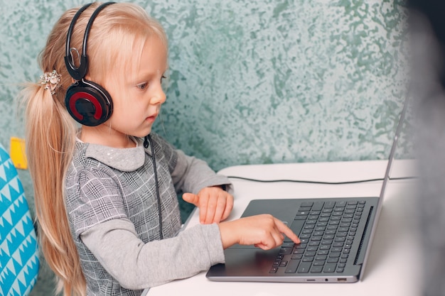 Kleines Mädchen des jungen Studenten mit Laptop, das zurück zur Schule lernt und sich vorbereitet.