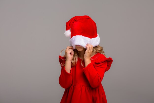 Kleines Mädchen die Blondine lächelt in einer Weihnachtsmannmütze