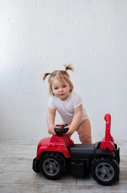 Kleines Mädchen fährt ein rotes Auto