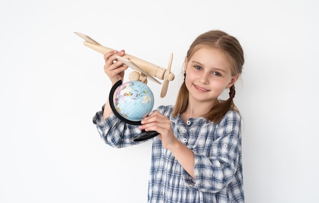 Kleines Mädchen fliegendes Flugzeugmodell um kleine Kugel