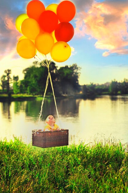 Foto kleines mädchen fliegt im korb auf den ballons