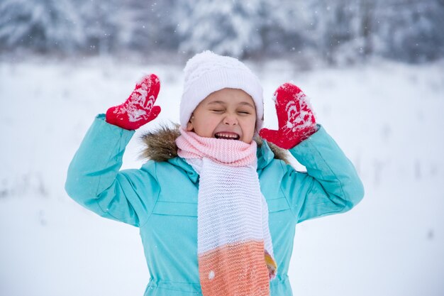 Kleines Mädchen freut sich im Schnee im Winter in der Natur. Emotionen. Winterspaziergang