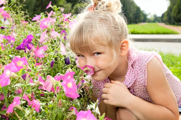 Foto kleines mädchen genießt den geruch von blumen