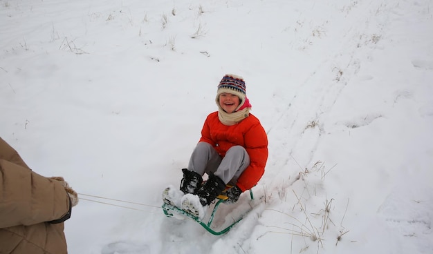 Kleines Mädchen hat Spaß im Winter mit Schlitten