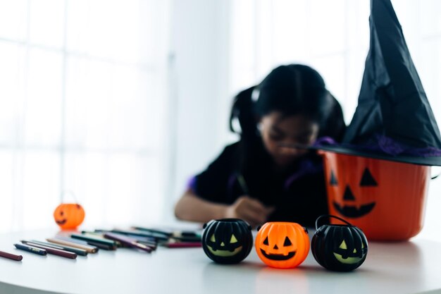 Kleines Mädchen im Halloween-Kostüm macht Jackolantern