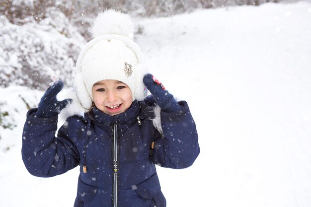 Foto kleines mädchen im kalten winter in warmen kleidern mit pelzgefütterten ohrpolstern