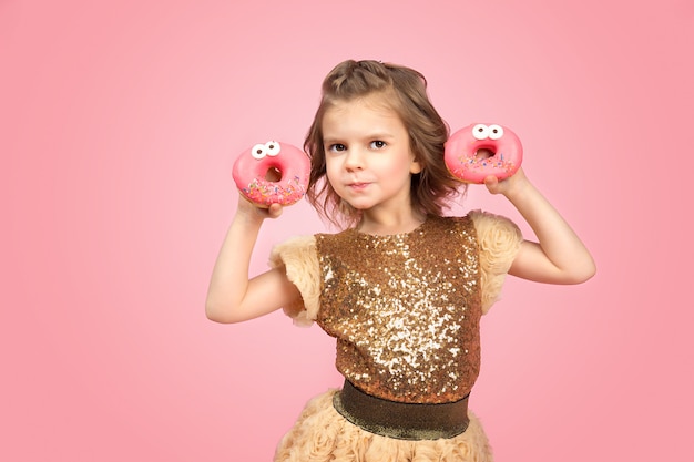 Foto kleines mädchen im kleid mit donuts