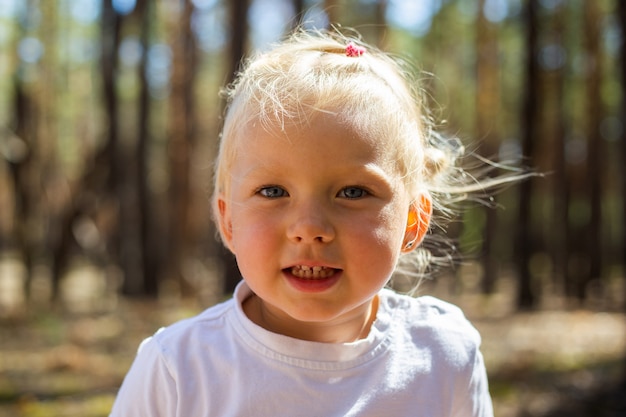 Kleines Mädchen im Wald. Gehen Sie mit den Eltern. Mit den Eltern spazieren gehen.