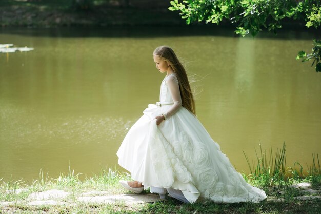 Kleines Mädchen im weißen Kleid im Freien