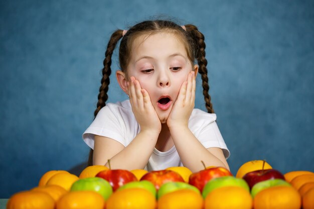 Kleines Mädchen im weißen T-Shirt liebt Obst