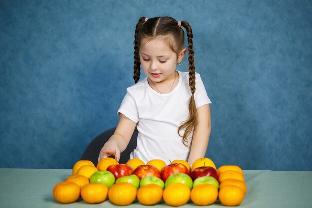 Kleines Mädchen im weißen T-Shirt liebt Obst