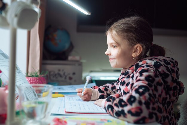 kleines Mädchen in der Ferne zu Hause Schule, Unterricht in Quarantäne.