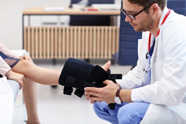 kleines Mädchen in der Klinik, das vom Orthopäden untersucht wird