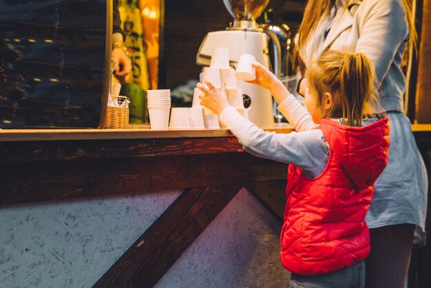 Kleines Mädchen in der Nähe der Theke auf Street Food Festival