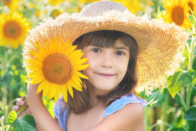 Kleines Mädchen in einem Feld der blühenden Sonnenblumen