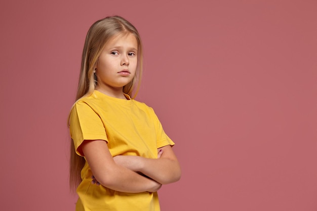 Kleines Mädchen in einem gelben T-Shirt. sieht beleidigt aus