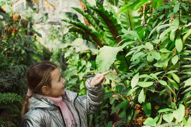 Kleines Mädchen in einem Gewächshaus oder Wintergarten