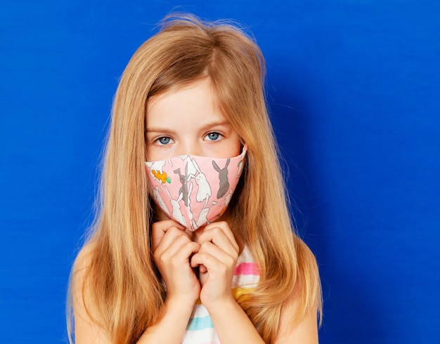 Kleines Mädchen in einer medizinischen Maske. Maskenprophylaxe zur Verringerung der Ausbreitung von Coronavirus-Ausbrüchen (Covid-19)