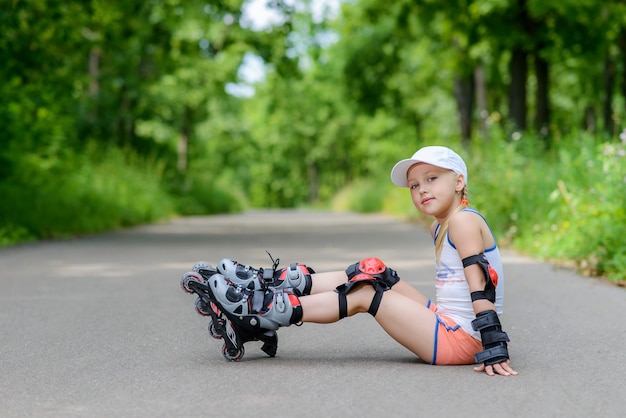 Kleines Mädchen in Rollschuhen an einem Park