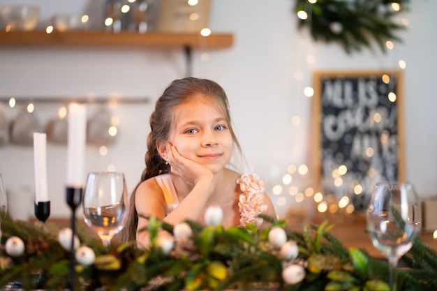 Kleines Mädchen ist gelangweilt, an Weihnachten am festlichen Tisch zu sitzen