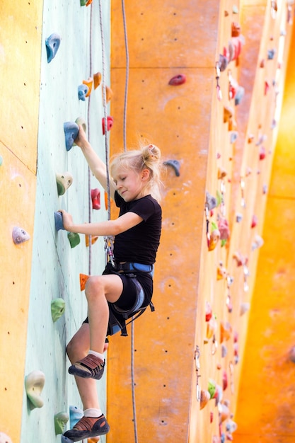 Kleines Mädchen klettert die Wand hoch