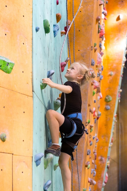 Kleines Mädchen klettert die Wand hoch