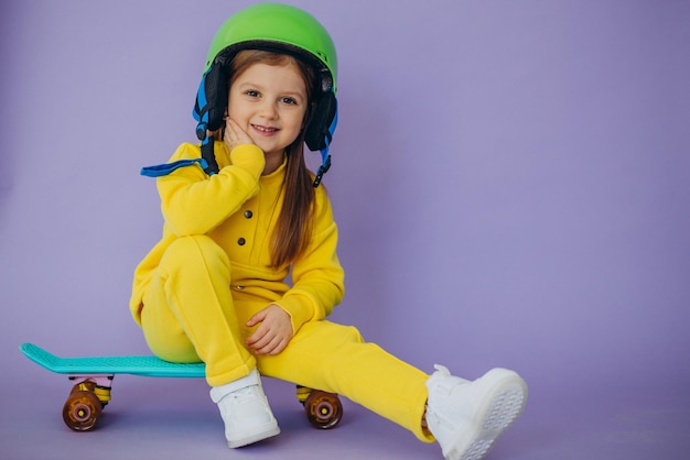 Kleines Mädchen lehrt, Skateboard mit Helm zu fahren