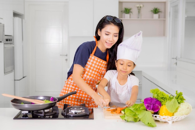 Kleines Mädchen lernt mit ihrer Mutter kochen
