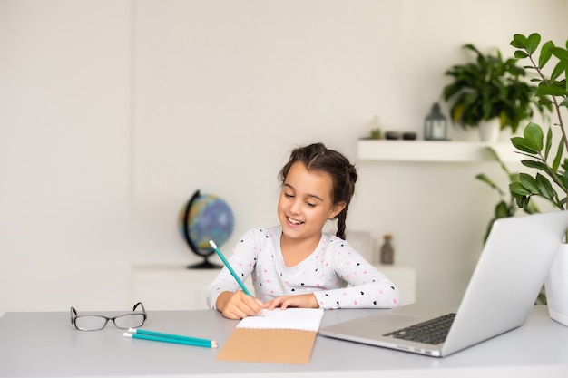 Kleines Mädchen lernt online mit ihrem Laptop zu Hause
