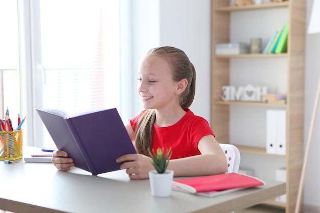 Kleines Mädchen liest zu Hause ein Buch