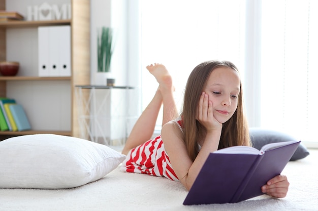 Kleines Mädchen liest zu Hause ein Buch