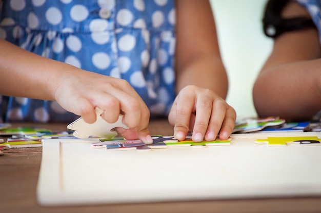 Kleines Mädchen macht ein Puzzle