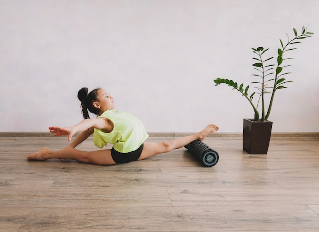 Kleines Mädchen macht Gymnastik zu Hause Online-Lernen Stretching-Schnur